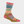Bright multi colored striped sock against a white background.