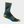A sock that is teal and grey with yellow, tel, and light blue stripes that has a dog with a white paddle on it.