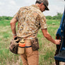 Person wearing a wait bag with multiple pockets in a field.