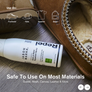 Image of a white bottle with black writing on it next to some slip on shoes on a wooden background.