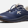 Side view of a dark blue and brown shoe with white accents with a big white K on the side and the word 'aspire' on the back outside of the heel.