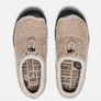 Top view of a Tan pair of fuzzy shoes with black rubber soles and a draw string at the top.