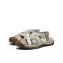 Pair of beige sandals with brown soles on a white background