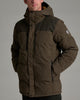 Close up image of a person wearing a dark brown jacket with their hands in the pockets against a medium grey background.