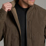 Person holding the collar of a brown jacket.