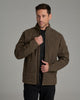 Person wearing a brownish green jacket against a grey background.