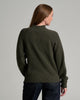 Back view of a person in a dark green sweater against a grey background.