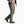 Person wearing pale dark green pants with a grey shirt and brown shoes against a white background.