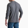 Back view of a person wearing a long sleeve grey shirt with blue jeans against a white background.