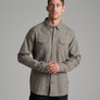 Person wearing a tan colored button up long sleeve shirt.