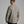 Back view of a person wearing a long sleeve tan shirt with a collar.