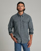 Person wearing a dark blue long sleeve button up shirt with a collar.