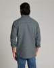 Back view of a person wearing a long sleeve shirt that is dark blue and has a collar.