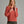 Person wearing a burnt orange sweater and green pants.