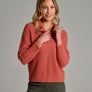 Person wearing a burnt orange sweater and green pants.