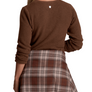 Person wearing a brown sweater with a brown and tan flannel tied around their waste against a white background.