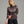 Person wearing a dark purple sweater with dark blue jeans against a grey background.