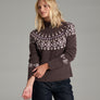 Person wearing a dark purple sweater with dark blue jeans against a grey background.