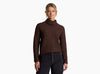 Person wearing a dark brown sweater against a white background.