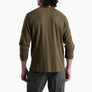 Back view of a person wearing a dark olive green long sleeve shirt and grey pants against a white background.