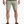 Person wearing pale green shorts with a dark green shirt and brown shoes against a white background.