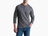 Person wearing a long sleeve grey shirt with 3 buttons and blue jeans against a white background.