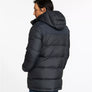 Back view of a person wearing a black puffy jacket with a hood against a white background.