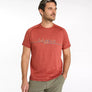 Man wearing a red t-shirt with a brand logo on a white background