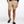 Person wearing beige shorts and brown loafers on a white background