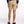 Person wearing beige shorts on a white background