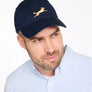 Man wearing a navy cap with a gold dog logo on a white background
