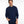 Person wearing a navy blue sweater against a white background.