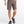 Person wearing brown cargo shorts on a white background