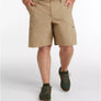 Person wearing beige shorts and green hiking shoes on a white background