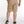 Person wearing beige shorts on a white background