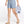 Person wearing light blue shorts with a white background