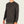 Person wearing a black long sleeve waffle knit shirt against a light grey background.