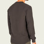 Back view of a person wearing a black long sleeve waffle knit shit against a white background.