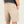 Beige shorts worn by a person on a light gray background