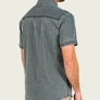 Person wearing a light grey short sleeve shirt with a blank background