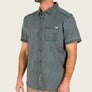 Man wearing a short sleeve light gray button up shirt with a pocket on the front