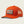 Orange trucker hat with a Marsh Wear patch on the front on a black background