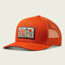 Orange trucker hat with a Marsh Wear patch on the front on a black background