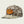 Mesh Camo trucker hat with Marsh Wear Co on the front with a beige background
