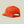 Back view of a bright orange snapback hat that has a small grey tag that says Marsh Wear on it against a pale green background.