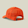 Back view of a bright orange snapback hat that has a small grey tag that says Marsh Wear on it against a pale green background.