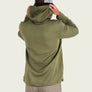 Person wearing a green ribbed hoodie from behind on a light beige background