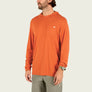Man wearing an orange long-sleeve hoodie with a brand logo on a beige background