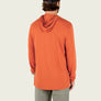 Person wearing an orange long sleeve with a hood against a blank background