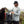 Man wearing a gray camo long sleeve with a hood interacting with a dog with nature in the background